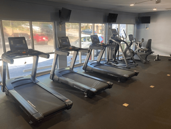 A gym with treadmills and elliptical machines.